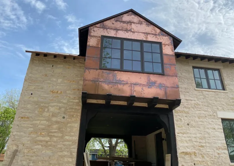 Copper metal panel facade on a stone building for Roof Repair in South Lyon